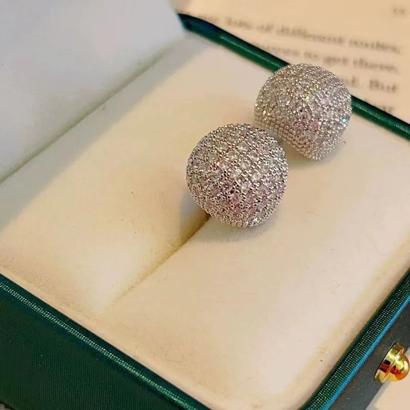 Gold geometric drop earrings with spherical elements and diamond detailing on clip-on backs