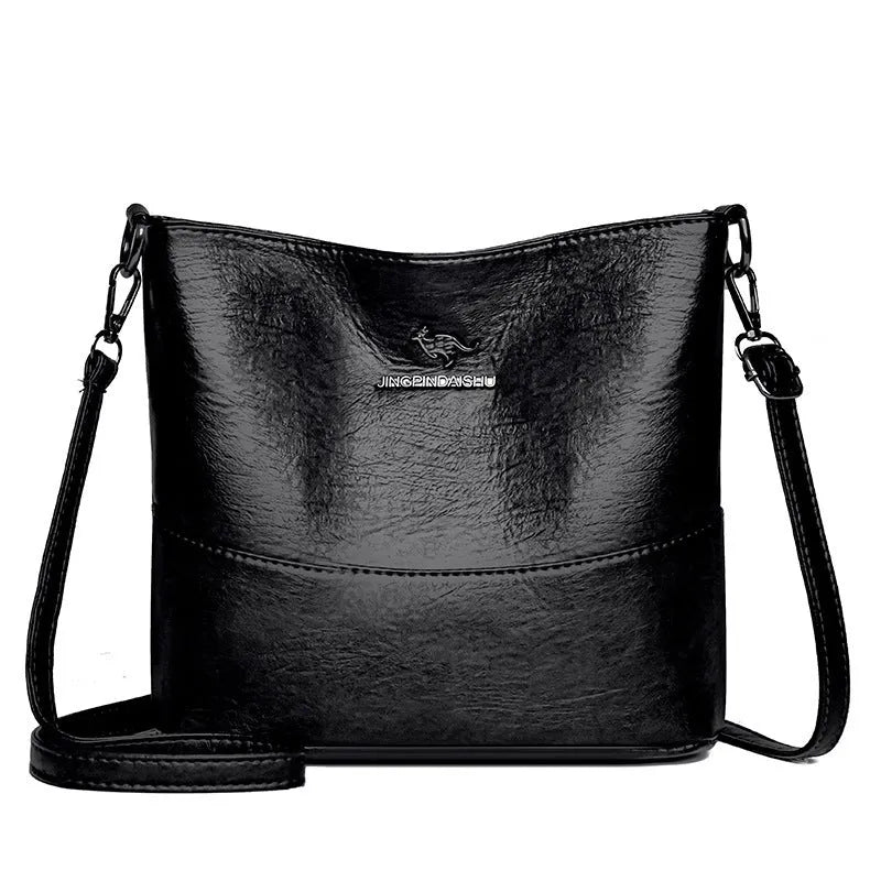 Women's soft leather bucket shoulder bag in black, shown with minimalist design and sewing line detail.