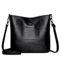 Women's soft leather bucket shoulder bag in black, shown with minimalist design and sewing line detail.