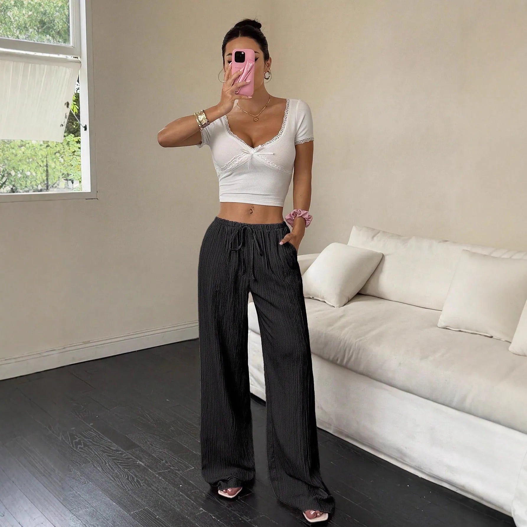 Women's black wide leg trousers with lace-up waist detail showing adjustable fit feature