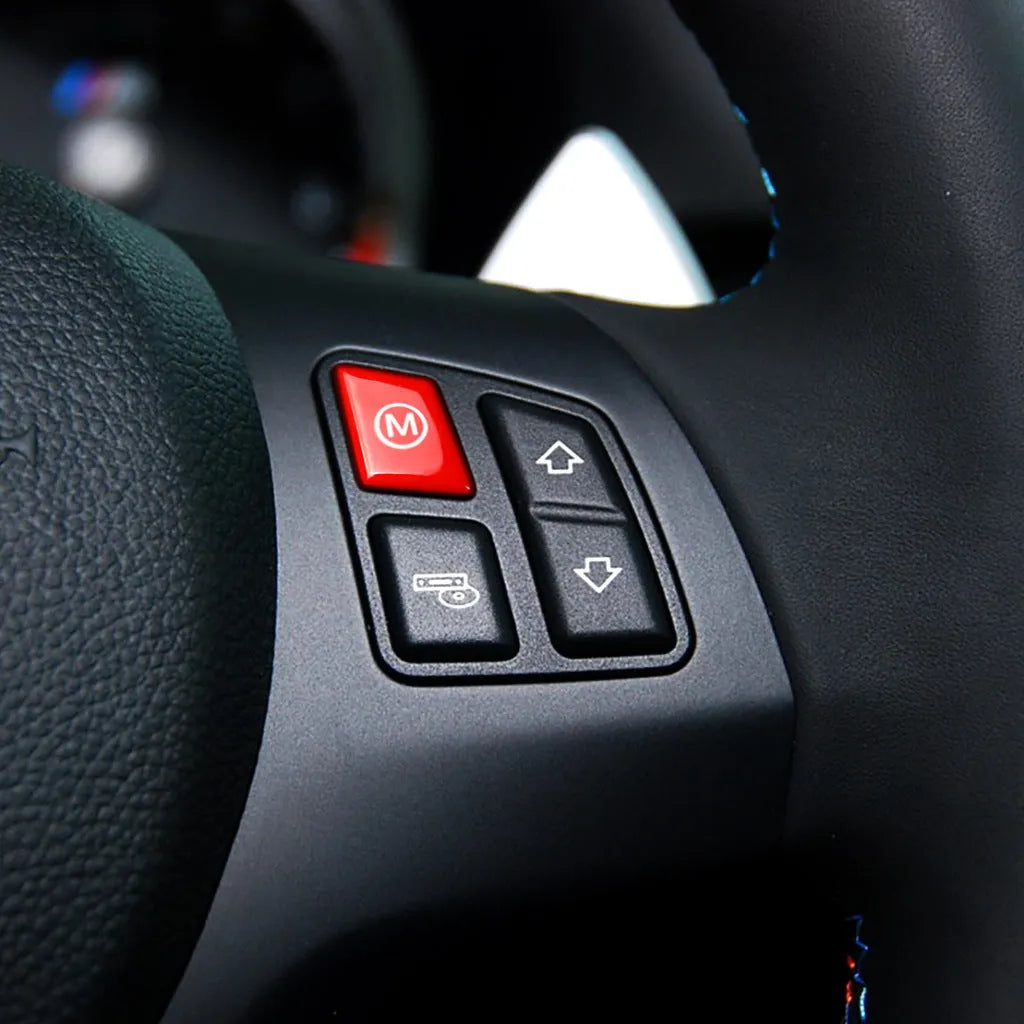 Pair of red and blue BMW M1 M2 steering wheel mode buttons with installation keys on a plain background.