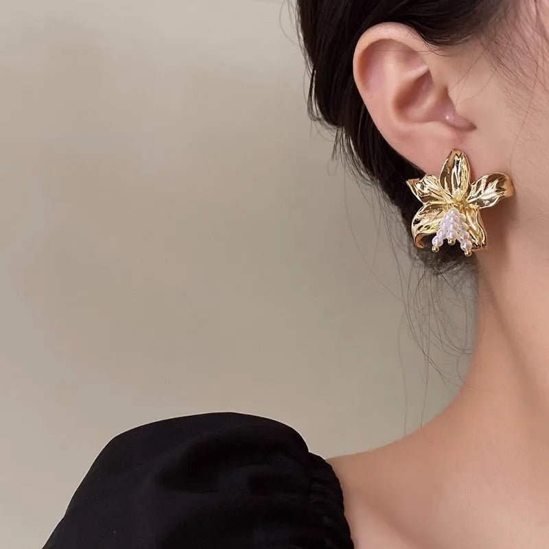 Gold H1795 flower earrings with exaggerated pearl accents on metal construction