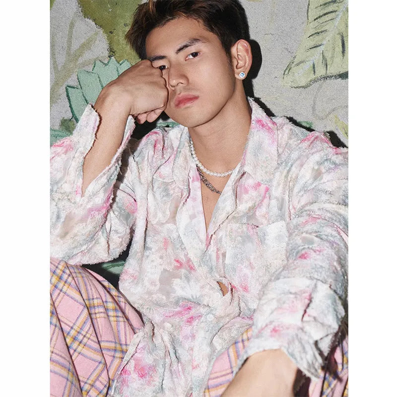 Man wearing a blue loose-fit long sleeve shirt with an embossed three-dimensional floral pattern.