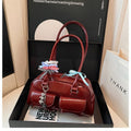 Retro women's black PU leather pillow-shaped shoulder bag with flap and double straps, shown with optional ribbon pendant.
