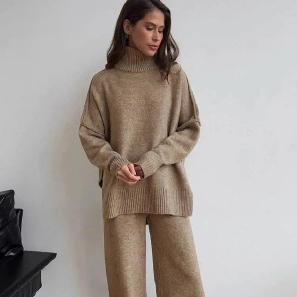 Women's acrylic suit set showing side-slit sweater top with matching trousers in solid colour