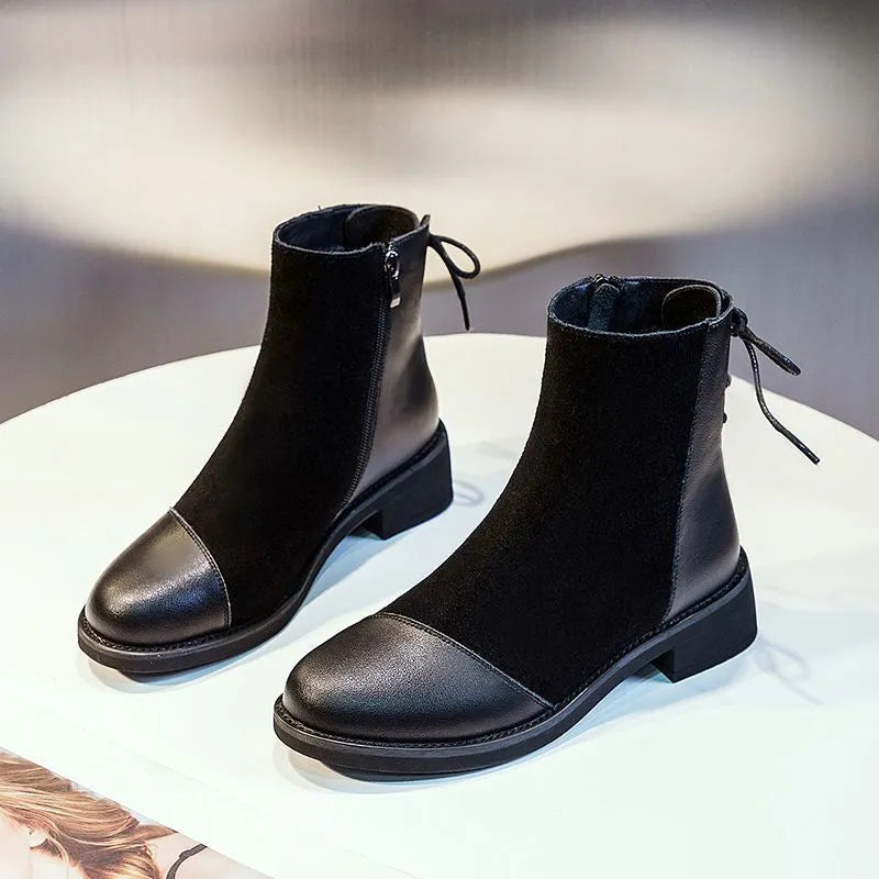Black women's knee-high Martin boots with side zip and round toe on a short stout heel.