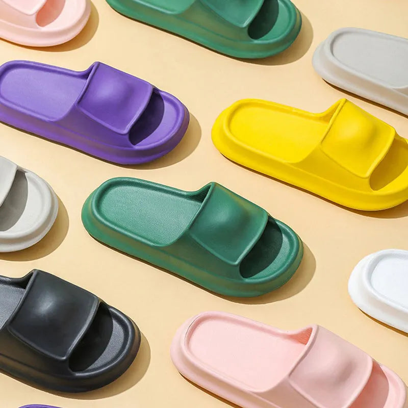 Thick-soled EVA flip-flop slippers in multiple colours on a bathroom floor, showing non-slip sole texture.