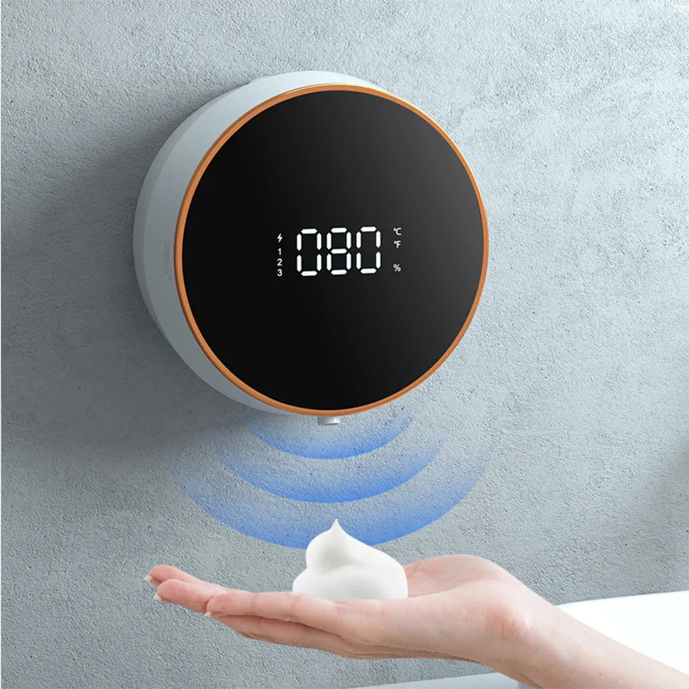Black automatic touchless foam soap dispenser mounted on a wall with USB charging cable.