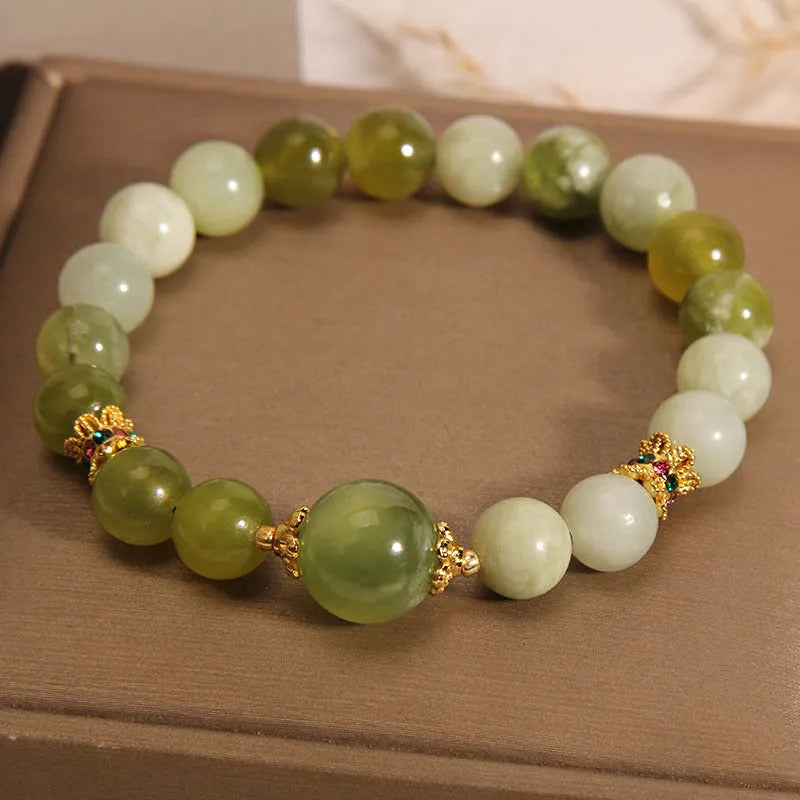 Xiuyan jade green women's bracelet with an original bangle design on a plain background.