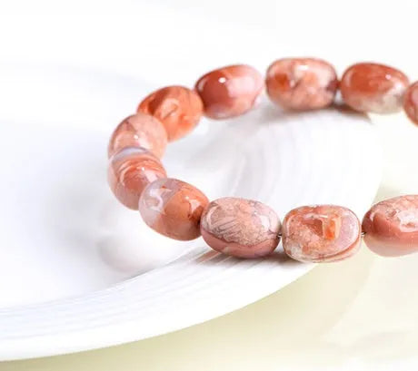 Natural cherry agate bracelet with barrel-shaped beads showing Ruyi geometric design