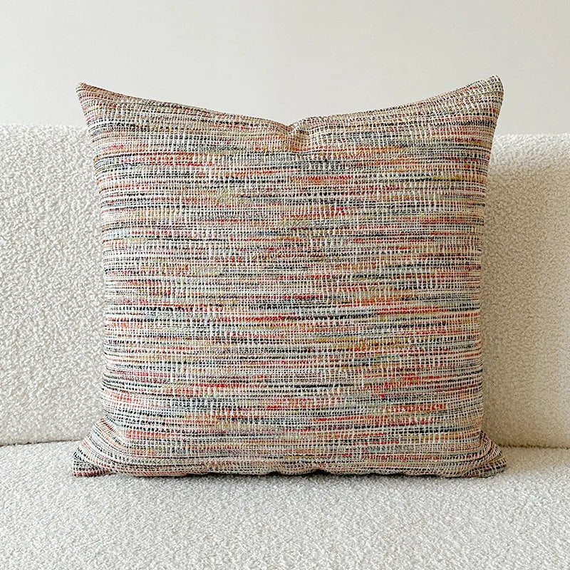 Amber-coloured jacquard pillow cover with paisley and flower pattern, shown in 45x45cm size on a sofa.