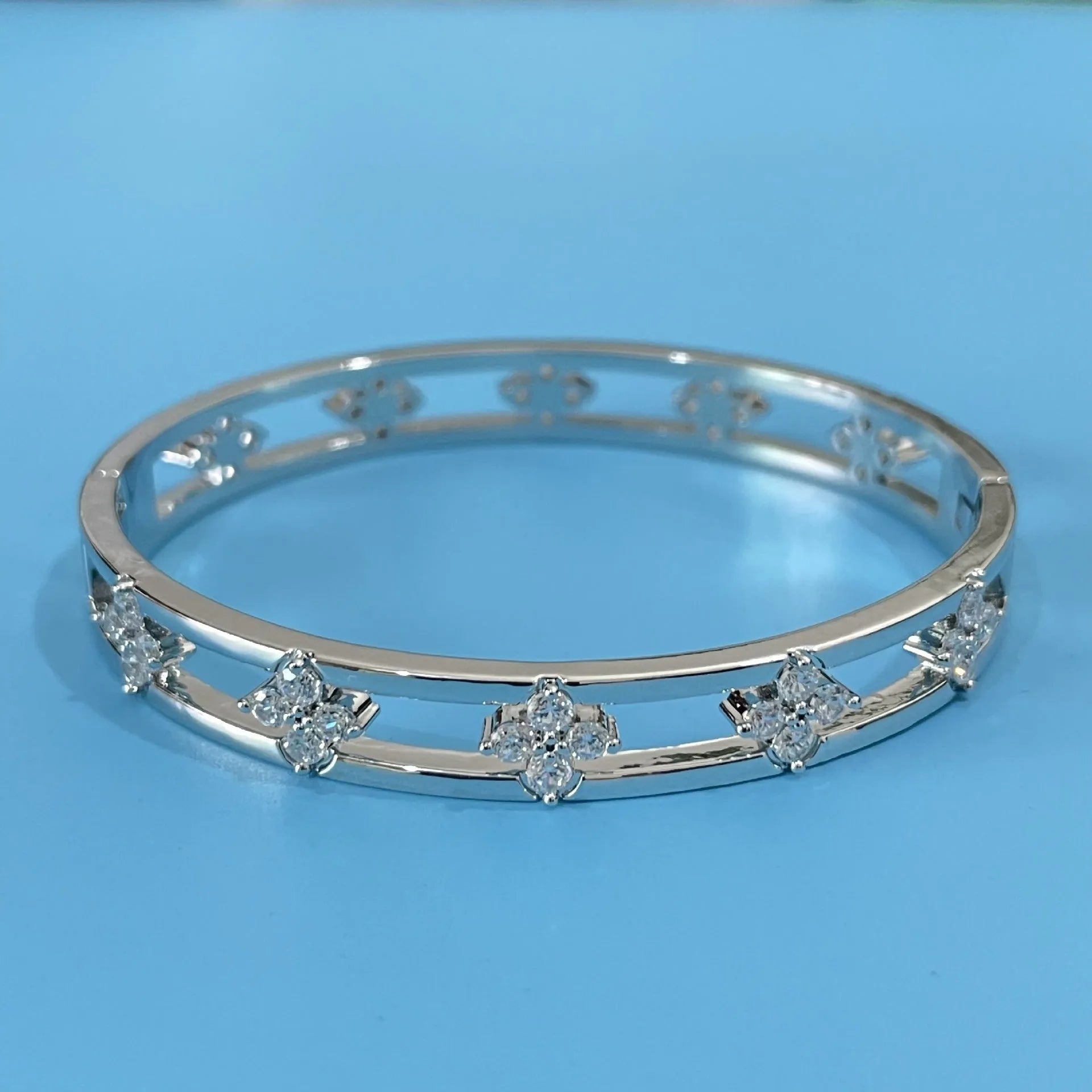 Gold or silver women's hollow bracelet with four-leaf clover design and zircon stones.