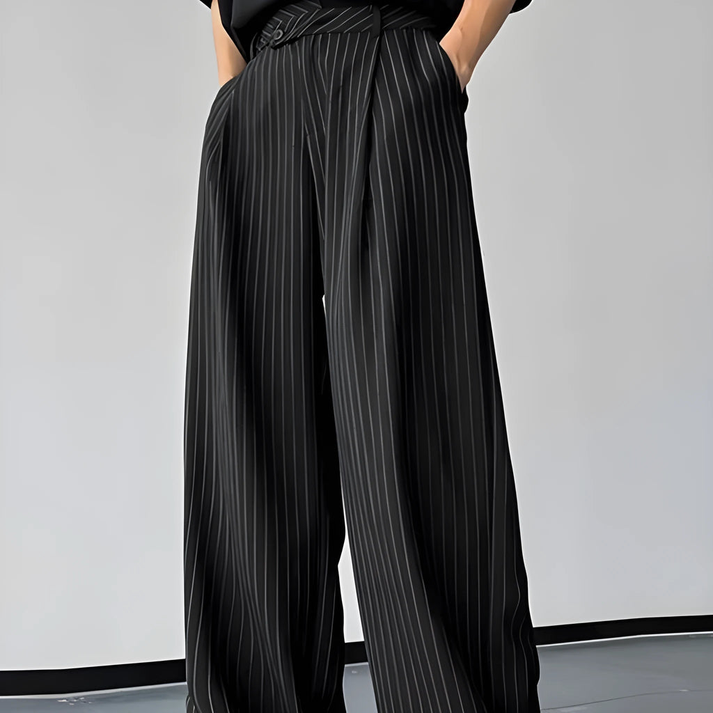 Men's black vertical striped pleated casual trousers showing elastic waistband and tapered leg
