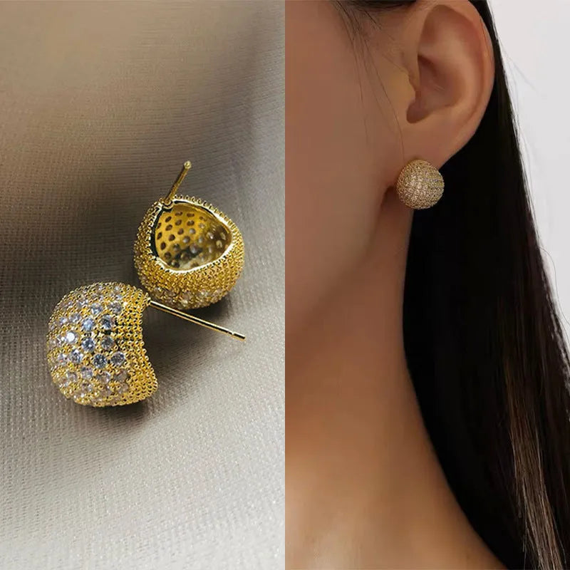 Gold geometric drop earrings with spherical elements and diamond detailing on clip-on backs