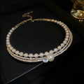 Close-up of a curved silver geometric clavicle chain necklace for women, resting on a collarbone.