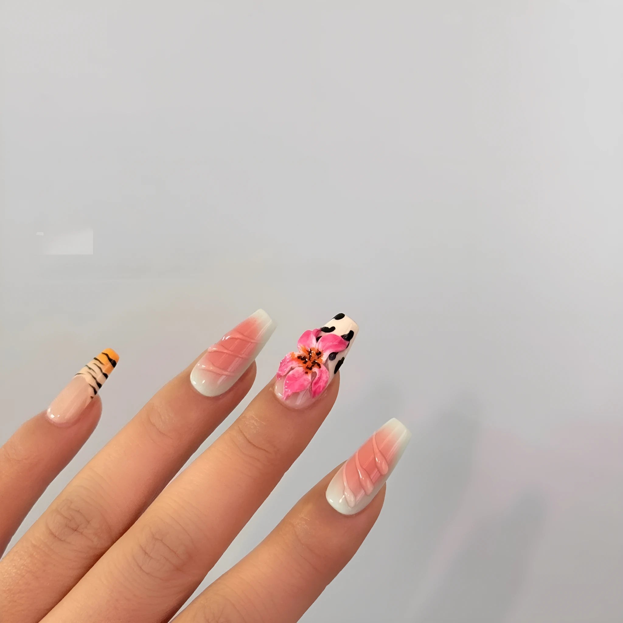 False nails with zebra pattern, carved lily design, and leopard print in long wear-resistant style.