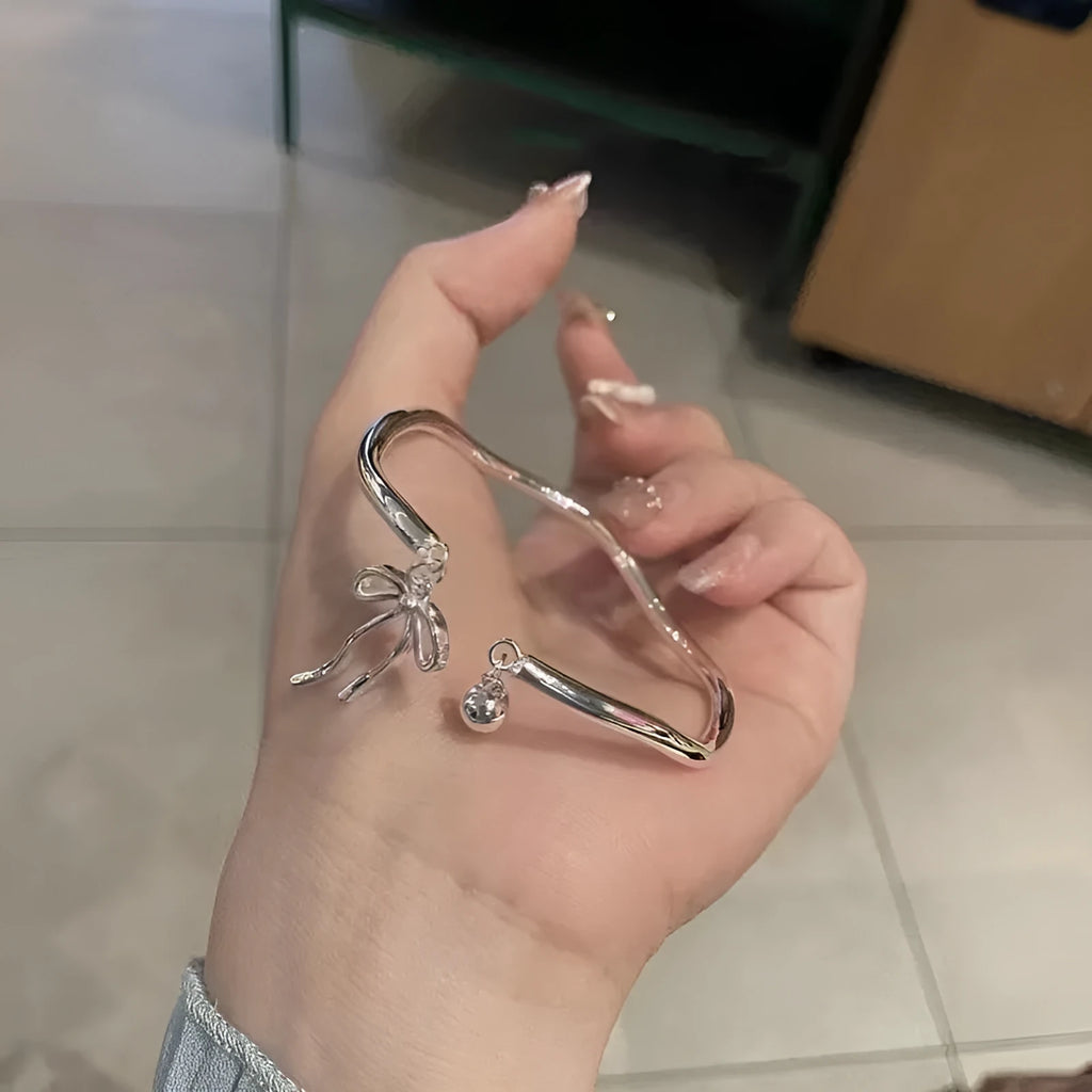 Silver adjustable bracelet with bow charm and bow bell opening clasp