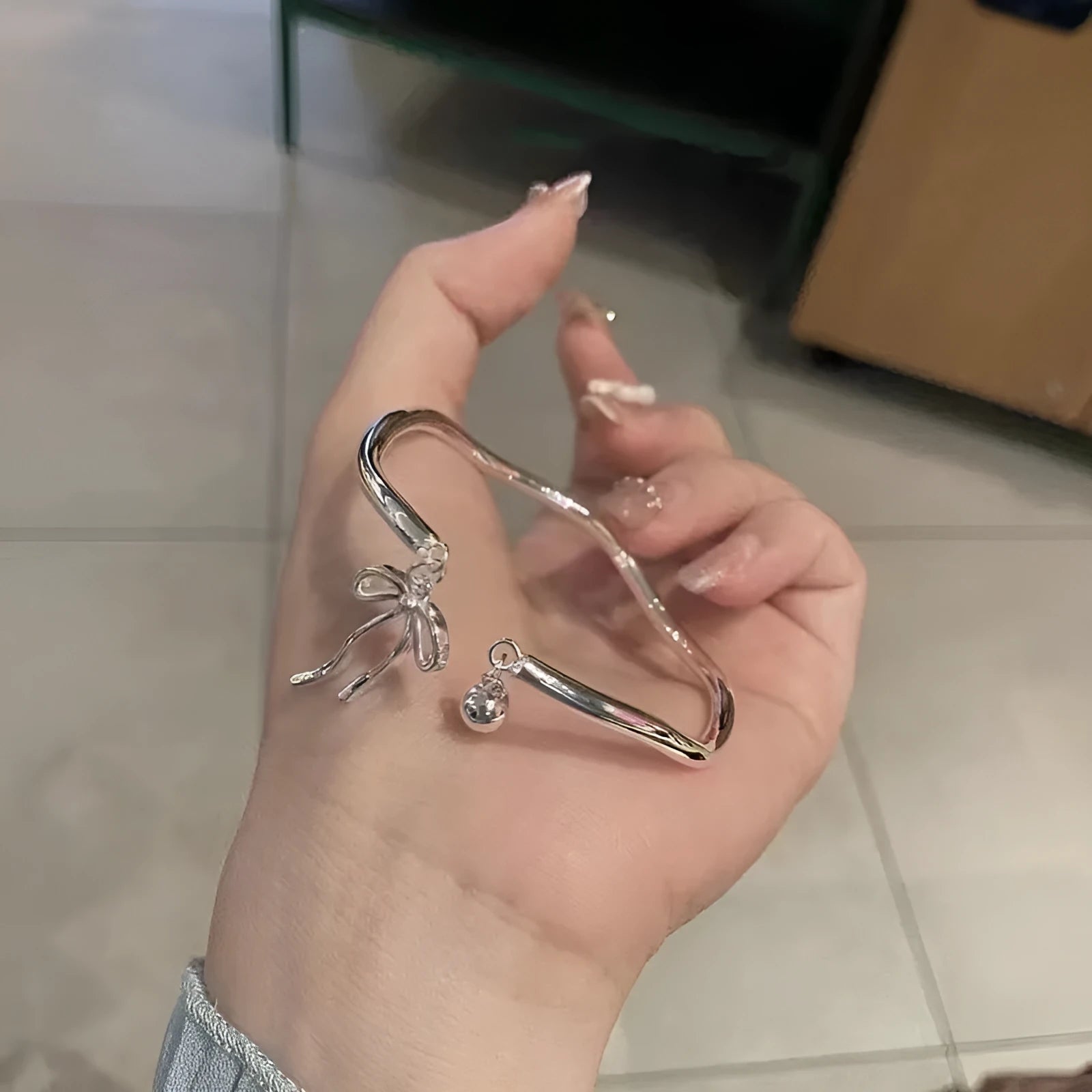 Silver adjustable bracelet with bow charm and bow bell opening clasp