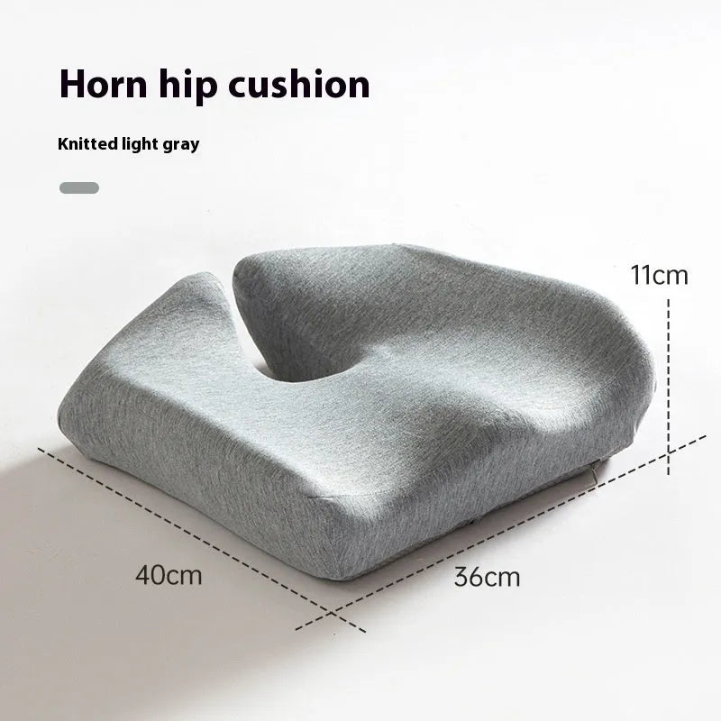 Dark grey memory foam office chair cushion with contoured shape for lower back support on a desk chair.