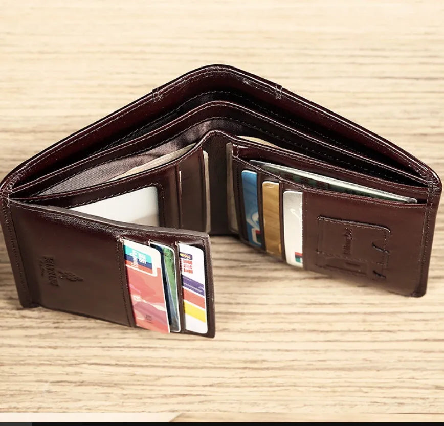 Men's black leather bifold wallet open to show internal card slots, photo window, coin pocket, and banknote compartment.
