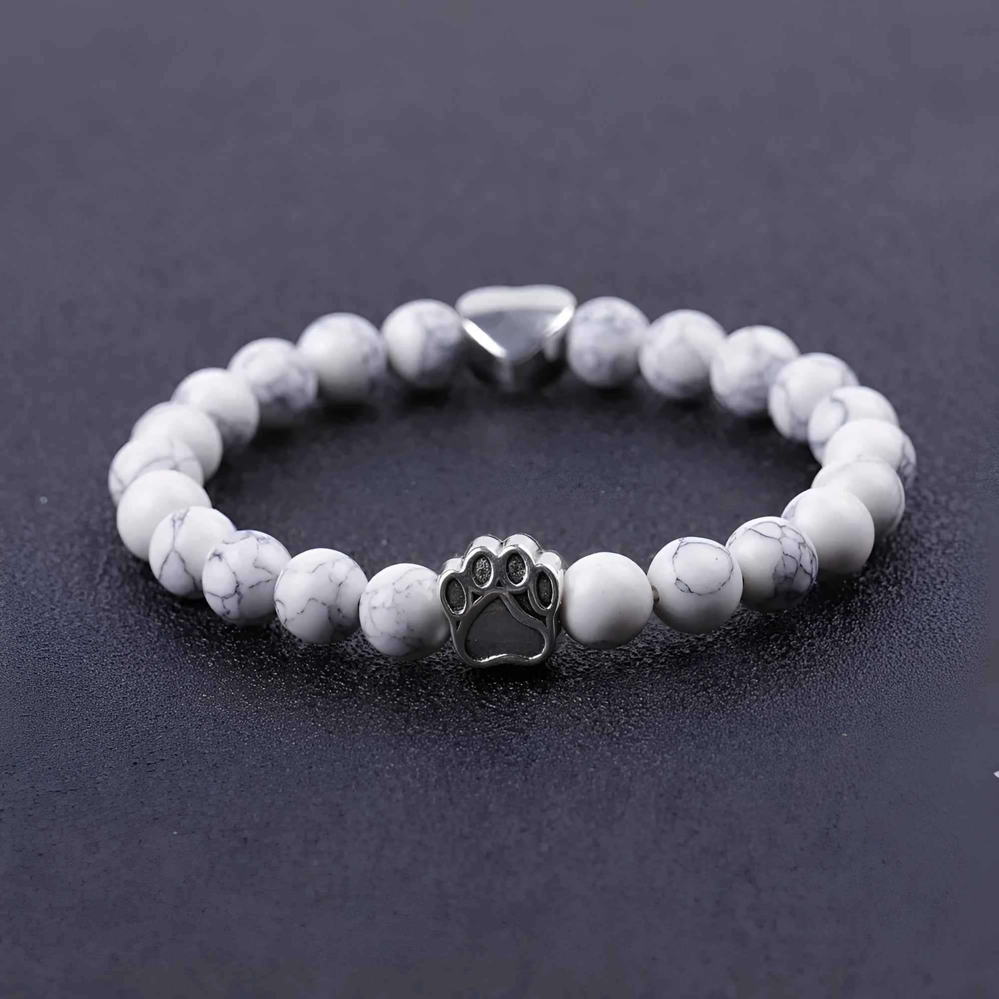 A round beaded stone bracelet in a Tiger Eye or Indian Agate style on a wrist.