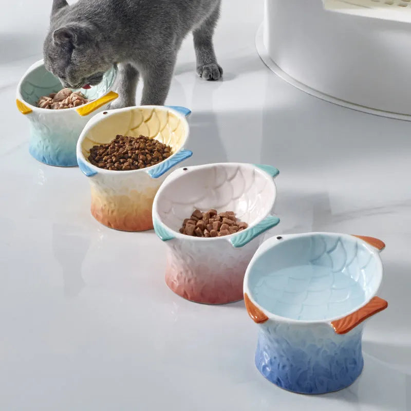 Set of four blue fish-shaped ceramic cat bowls with tilted design and elevated base