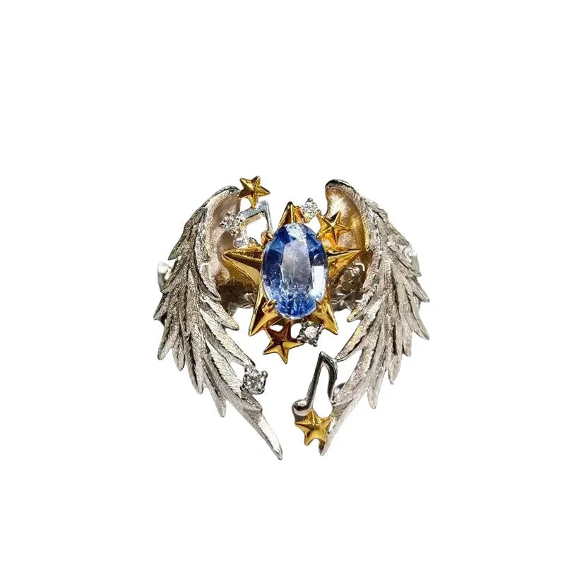 Gold-tone geometric angel wings alloy ring with adjustable opening on a finger.