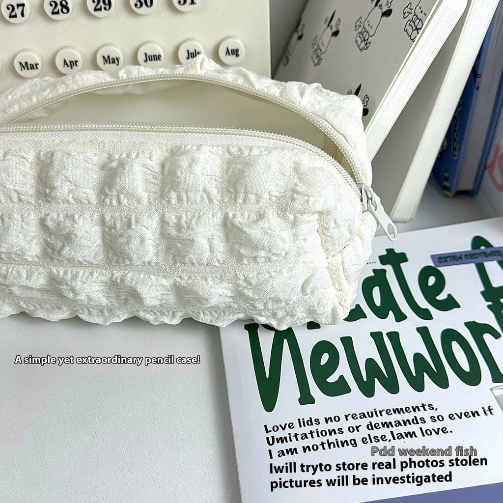 Beige fabric pencil case with cream puff character design and black zip closure
