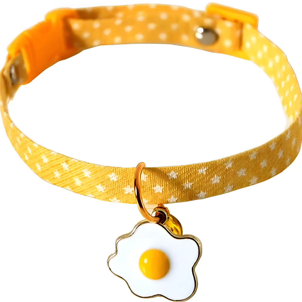 Adjustable green pet collar with a silver bell and a pink bow tie on a small dog.