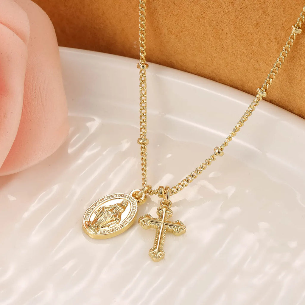 Gold Virgin Mary and cross geometric pendant necklace on a simple chain.