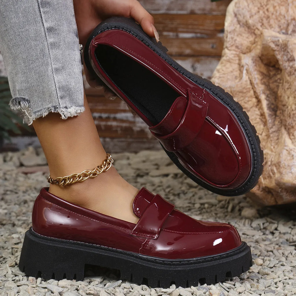Plus size black slip-on loafers with a chunky platform heel and thick rubber sole.