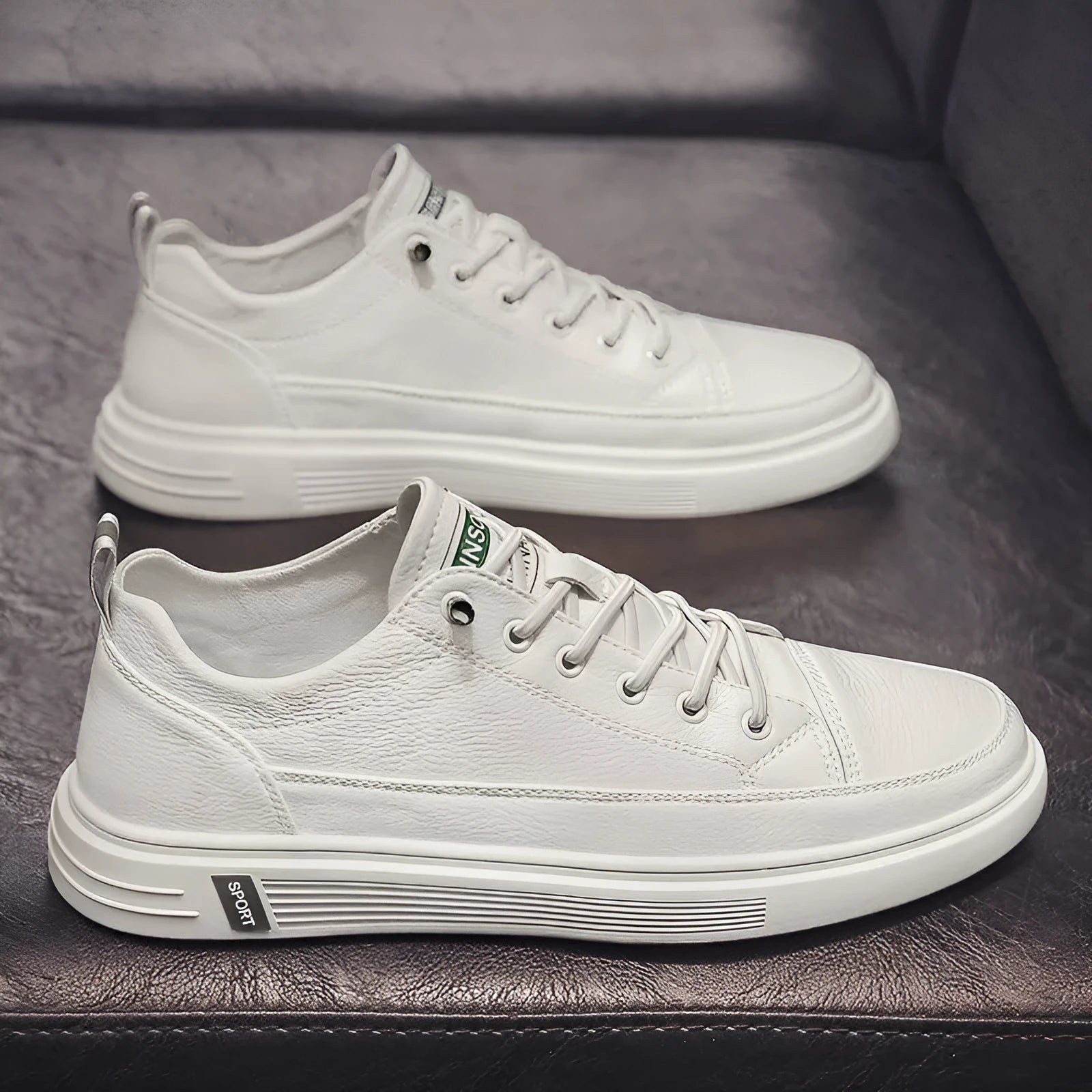 Men's white casual flat shoes with round toe and low heel on a plain background.
