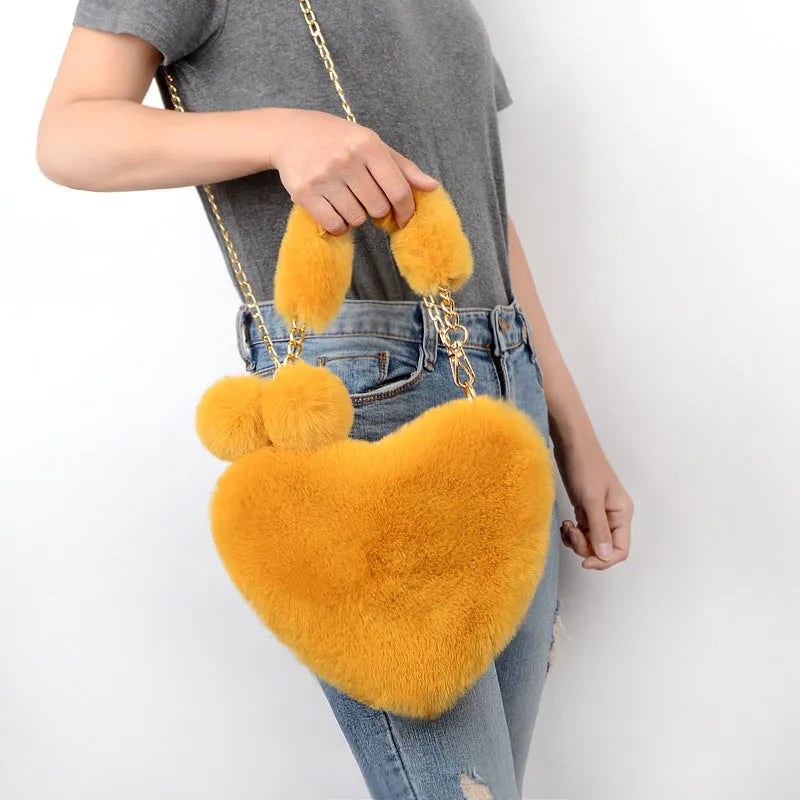 Soft plush women's handbag in a red heart shape with a zipper and detachable strap.