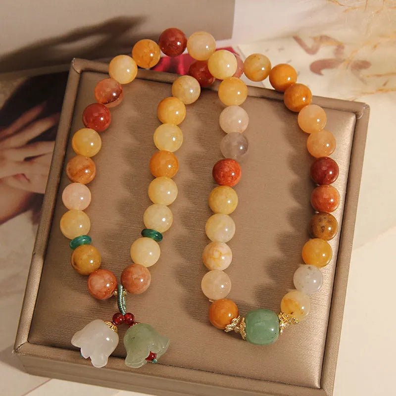 Natural green jinsi jade multi-layer bracelet for women with an orchid pendant charm on an elastic band.