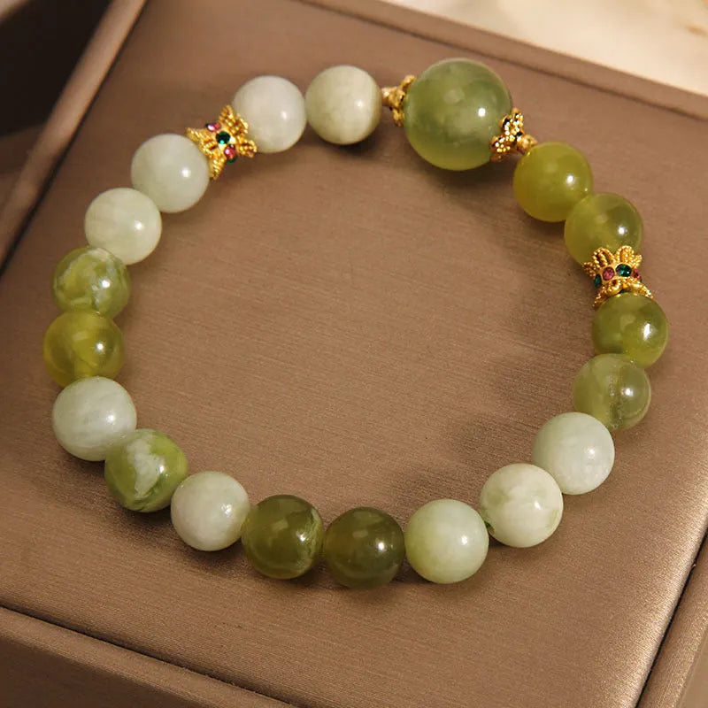 Xiuyan jade green women's bracelet with an original bangle design on a plain background.