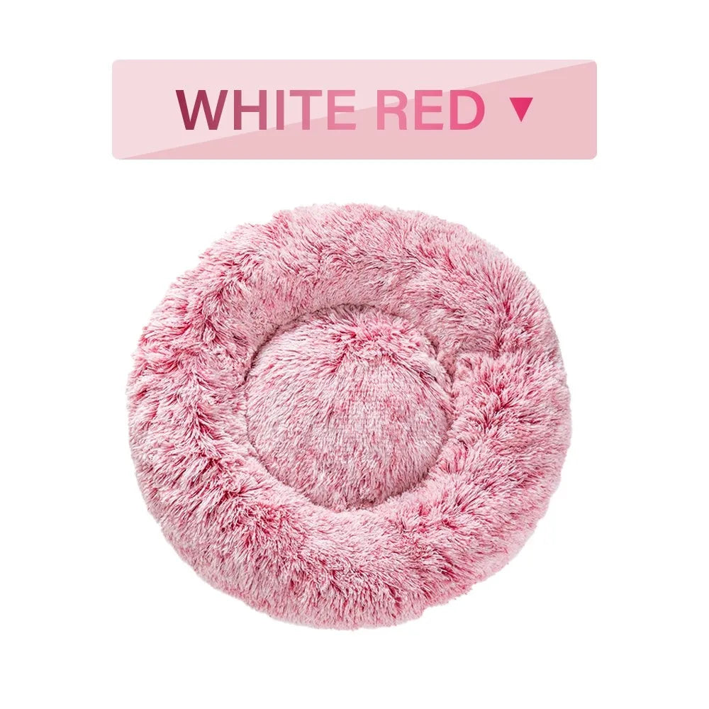 Fluffy donut-shaped dog bed in long plush fabric, shown in a light grey colour with a raised edge.