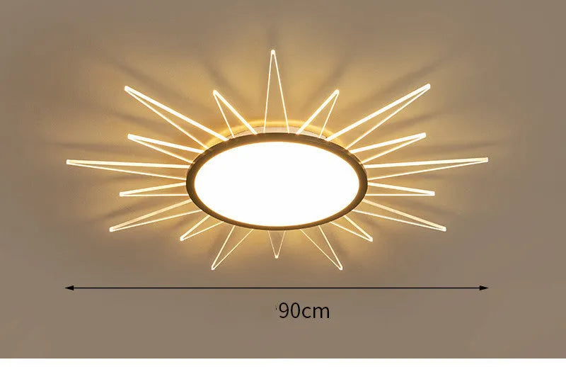 Modern round aluminium LED ceiling lamp with remote control shown in a living room setting.
