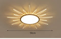 Modern round aluminium LED ceiling lamp with remote control shown in a living room setting.