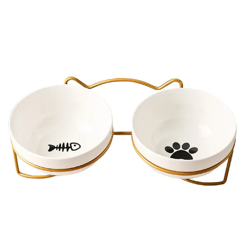 White ceramic pet bowl with cat paw design on a black metal stand with cat ear details.
