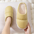 Blue down cotton indoor slippers with thick rubber sole and plush lining, shown on a wooden floor.