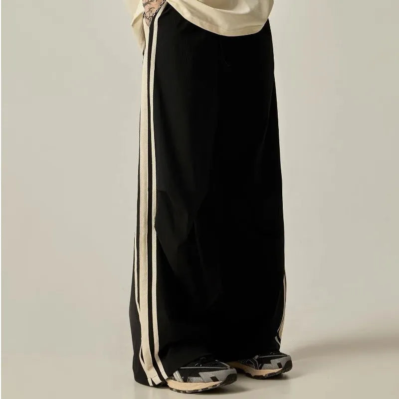A man wearing black high-waisted wide-leg straight-cut casual climbing trousers.