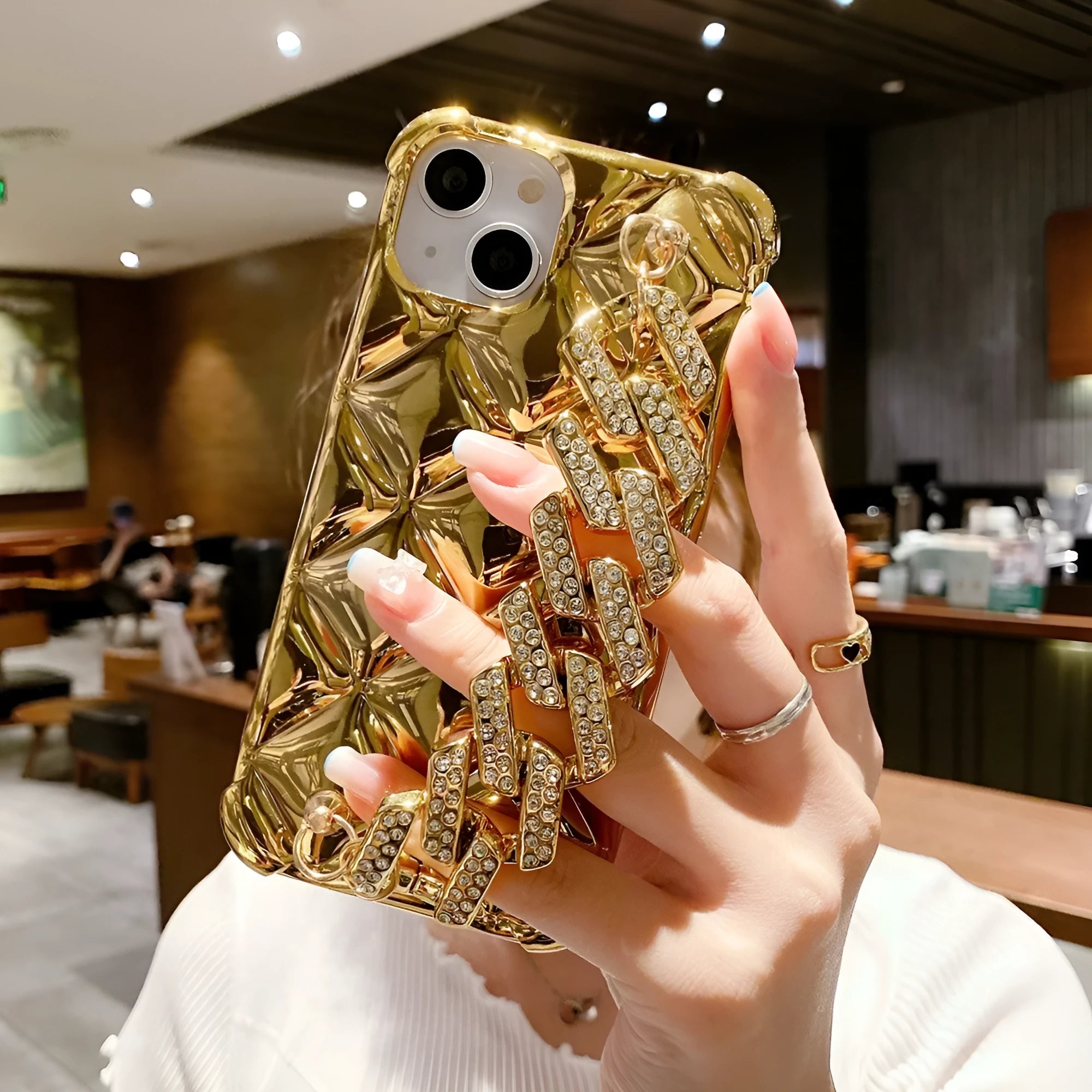 Silver and gold luxury diamond bracelet iPhone cases with chain strap and lock charm for various models.