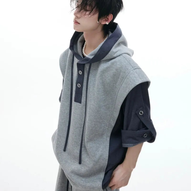 Man wearing a black hooded short-sleeve polyester tracksuit jacket and grey matching trousers.