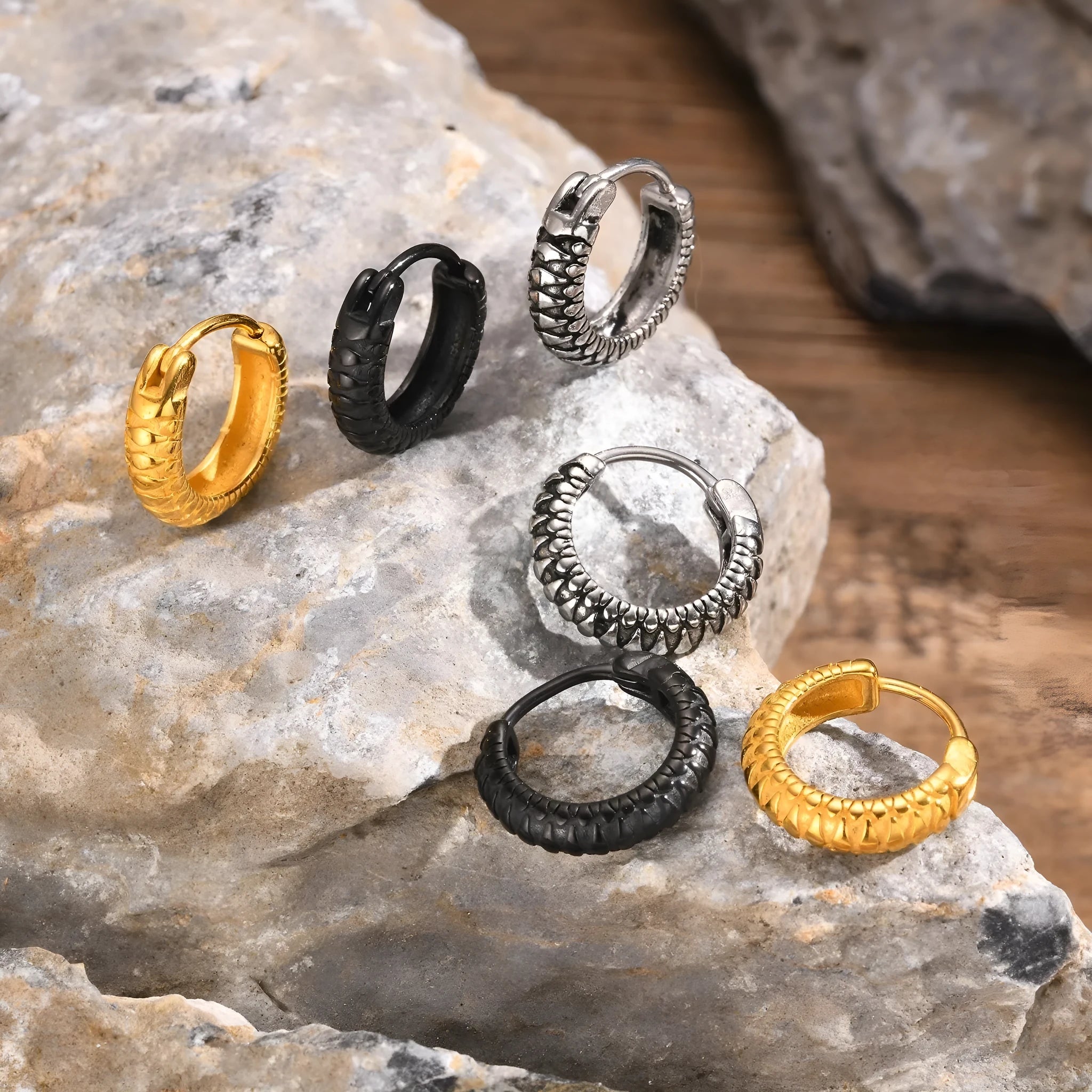 A pair of stainless steel earrings with a snake pattern design in black or gold.