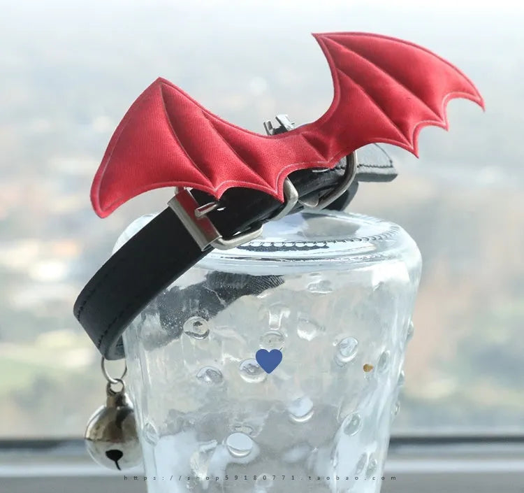Small leather dog collar with decorative devil wings and bell in patent leather satin
