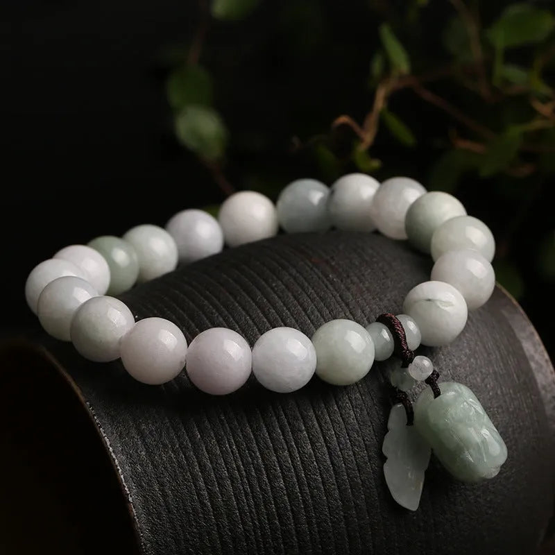 Natural green jade bracelet with hanging geometric charms including an Apple and a Maitreya Buddha pendant.