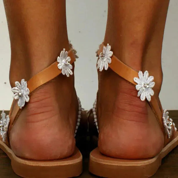 Brown Roman sandals with floral decoration and flat rubber soles