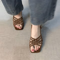 Retro women's sandals with thin cross straps, ankle buckle, and a mid heel on a square toe.