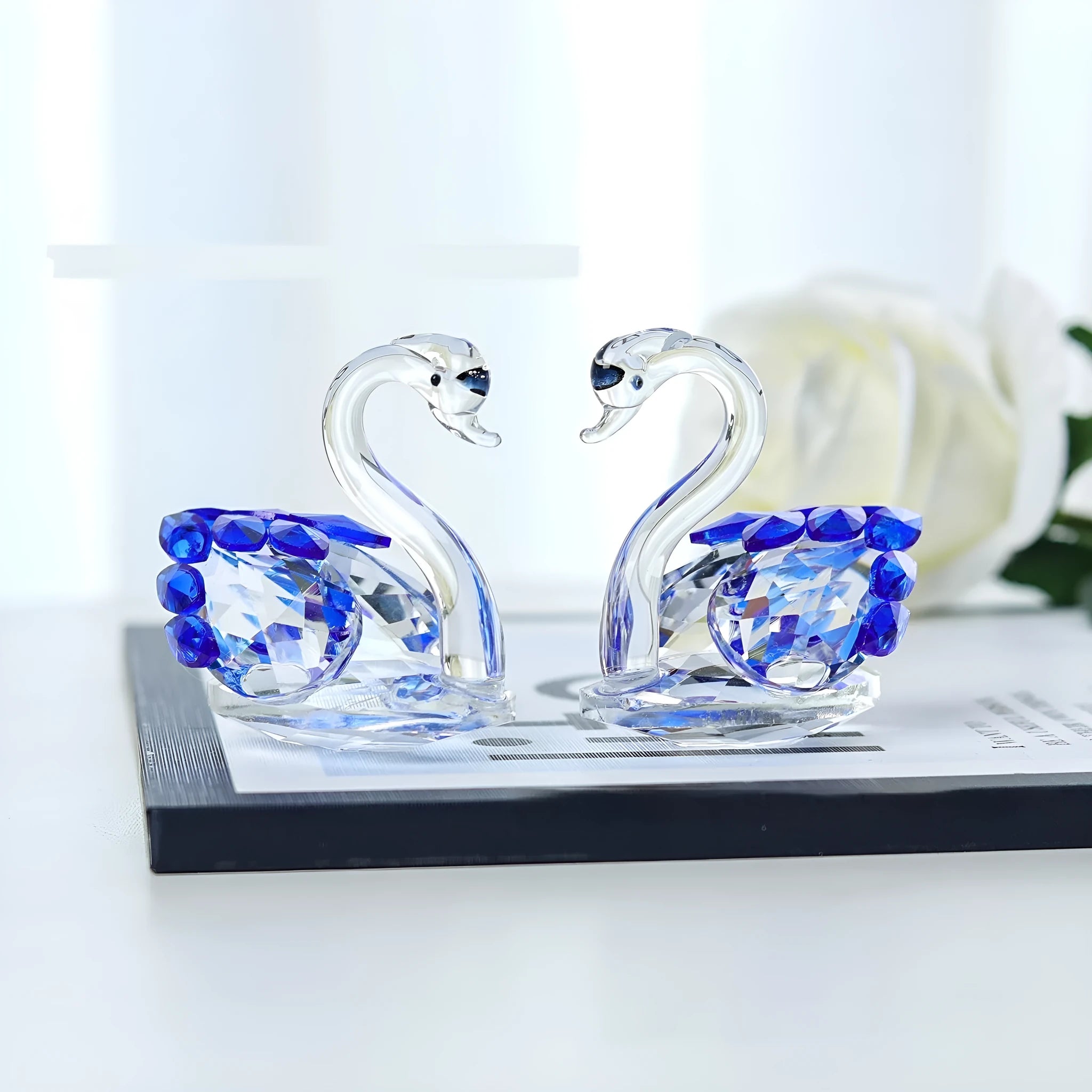 White crystal swan decoration on desktop with red, blue, pink, and violet colour options
