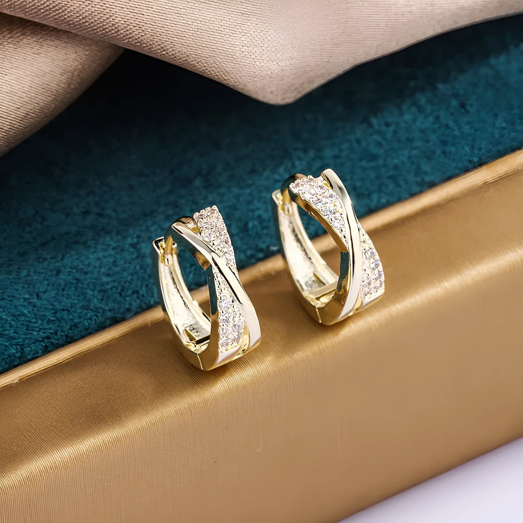 A pair of geometric drop earrings made from copper with zircon detailing and a 14K yellow finish.